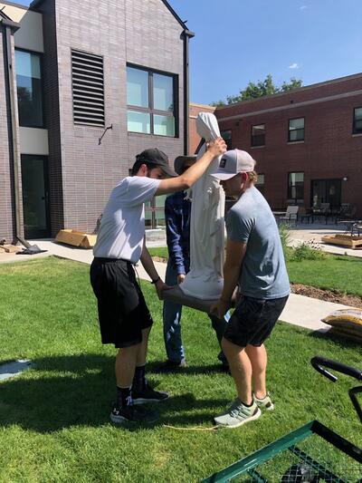 Brothers carrying in the statue