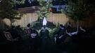 Dominicans praying to Rosary at night around a statue of Mary, the Mother of Mercy in the garden